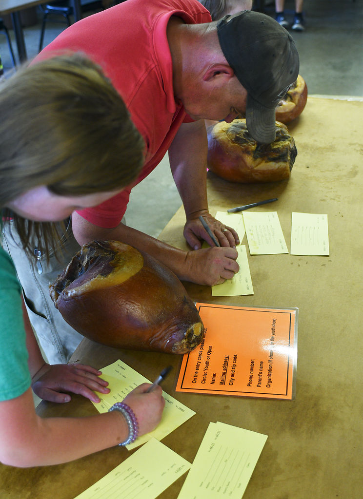 Seth Frerking and his daughter, Allie Frerking, 7, enter their hams in the 2019 Ham Show at the Boone County Fair